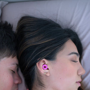 Pareja durmiendo mientras usa los tapones para los oídos reutilizables Mood Earplugs Focus Pink, diseñados para reducir el ruido de los ronquidos