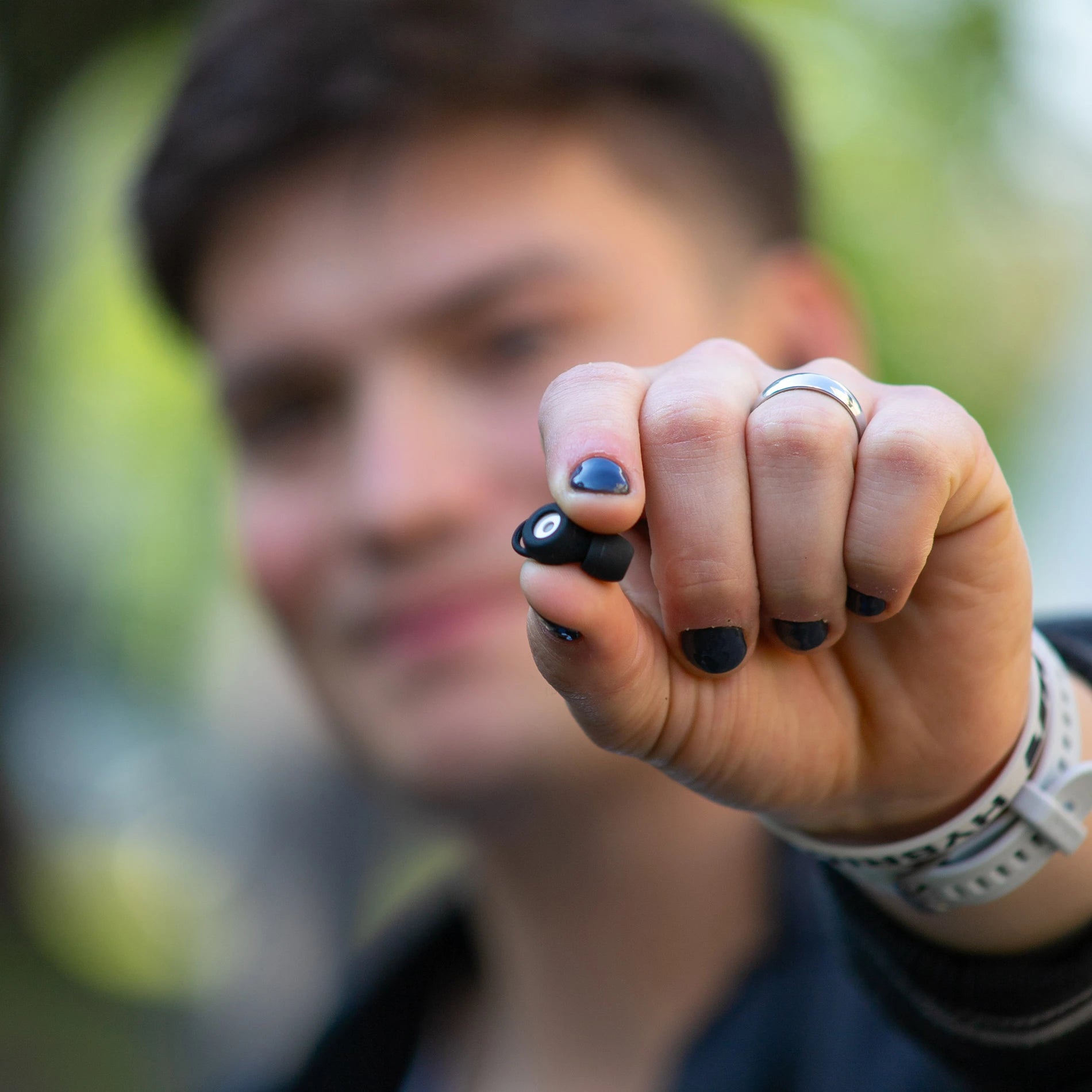 Tapones para los oídos Mood Earplugs Chill Black sostenidos en la mano, con filtro acústico visible.