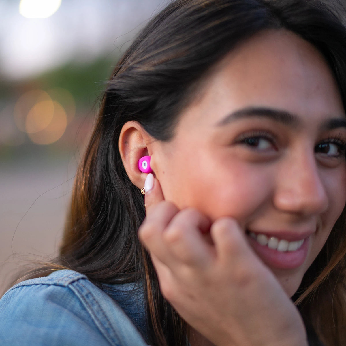 Mujer usando los tapones para los oídos reutilizables Mood Earplugs Chill Pink, diseño cómodo y color vibrante