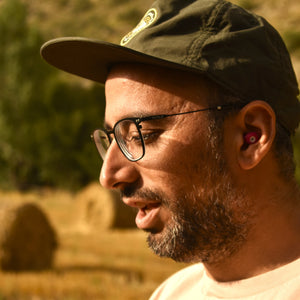 Hombre usando los tapones para los oídos reutilizables Mood Earplugs Chill Pink en un entorno natural y tranquilo