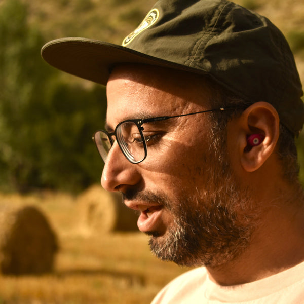 Hombre usando los tapones para los oídos reutilizables Mood Earplugs Chill Pink en un entorno natural y tranquilo