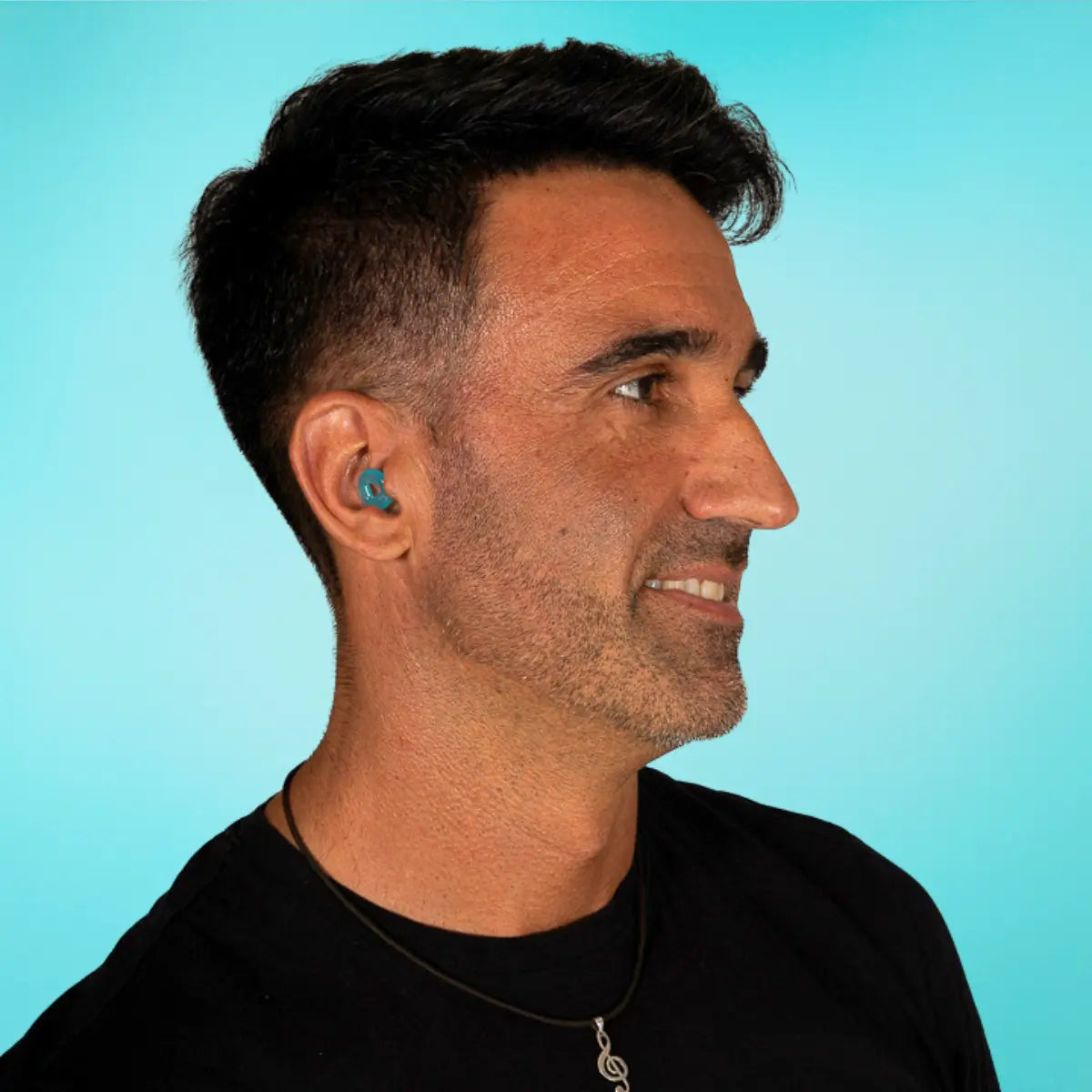chico joven moreno llevando los tapones auditivos de la marca española Mood Earplugs de color turquesa